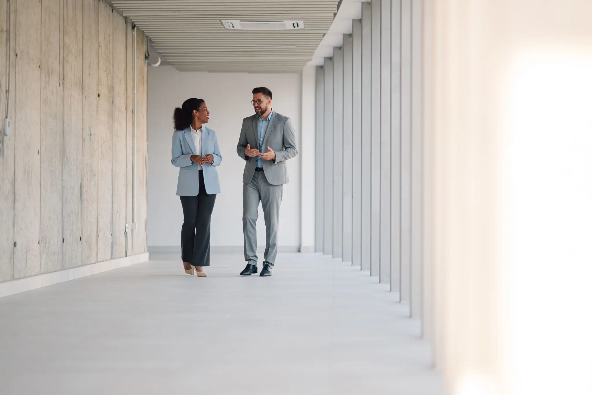 Business professionals engaged in conversation indoors.